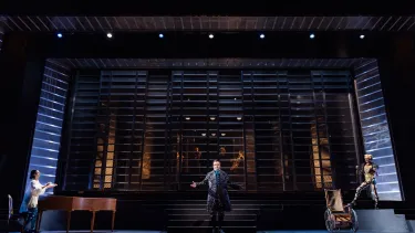 A man on the stage with his arms open.